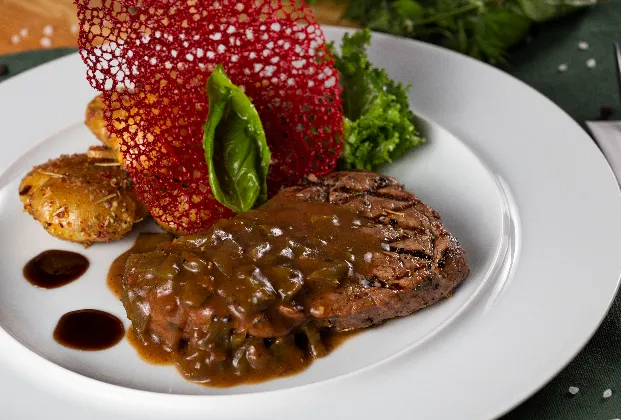 Pepper steak with whole peppercorns, demi-glace sauce and spiced potatoes