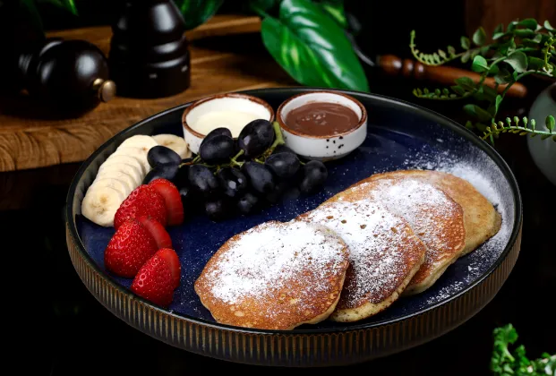 Pancakes with chocolate, white chocolate, banana, strawberry and grapes