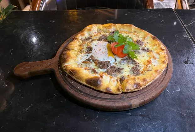 Trabzon pide with egg, kavurma, and kaşar cheese
