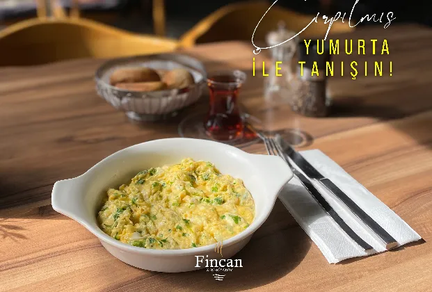 Scrambled eggs with white cheese and green herbs