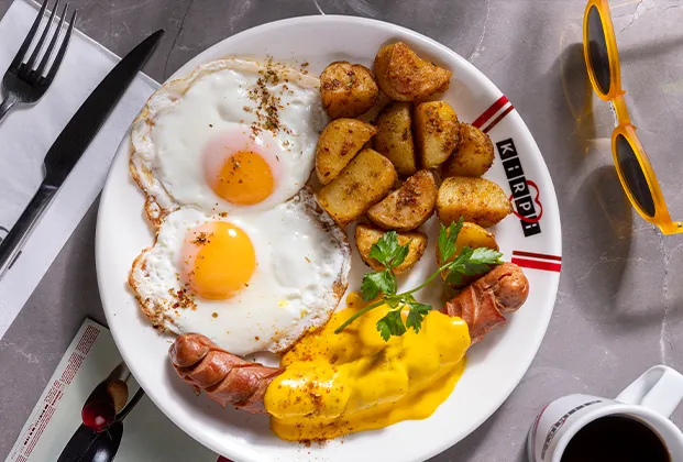Frankfurter sausage, baked potato and two sunny-side-up eggs