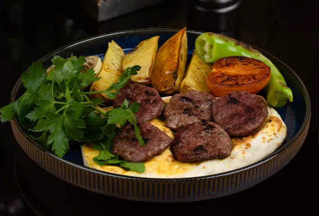 Kasap köfte with oven potatoes, roasted tomato and pepper